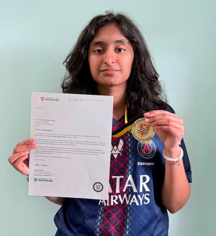 Yana holding the University of Waterloo CHEM 13 News award letter and medal