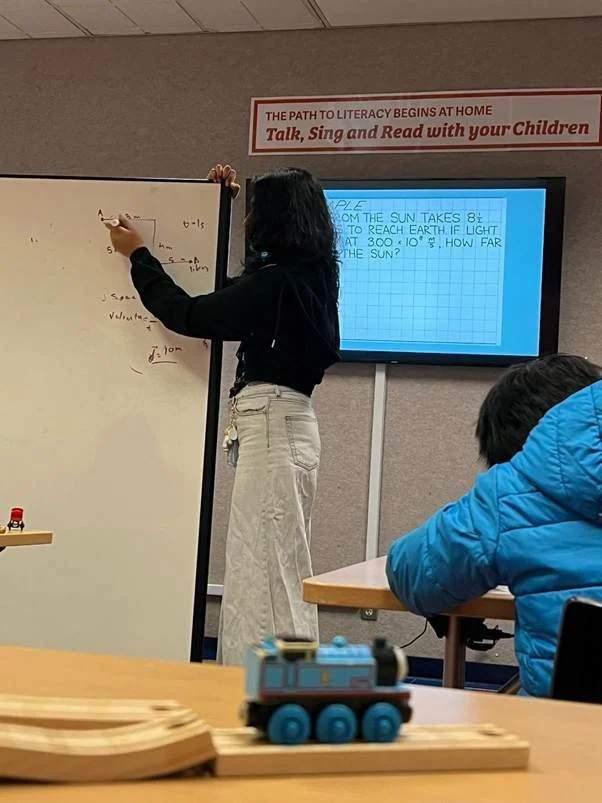 Teaching a physics lesson at a whiteboard